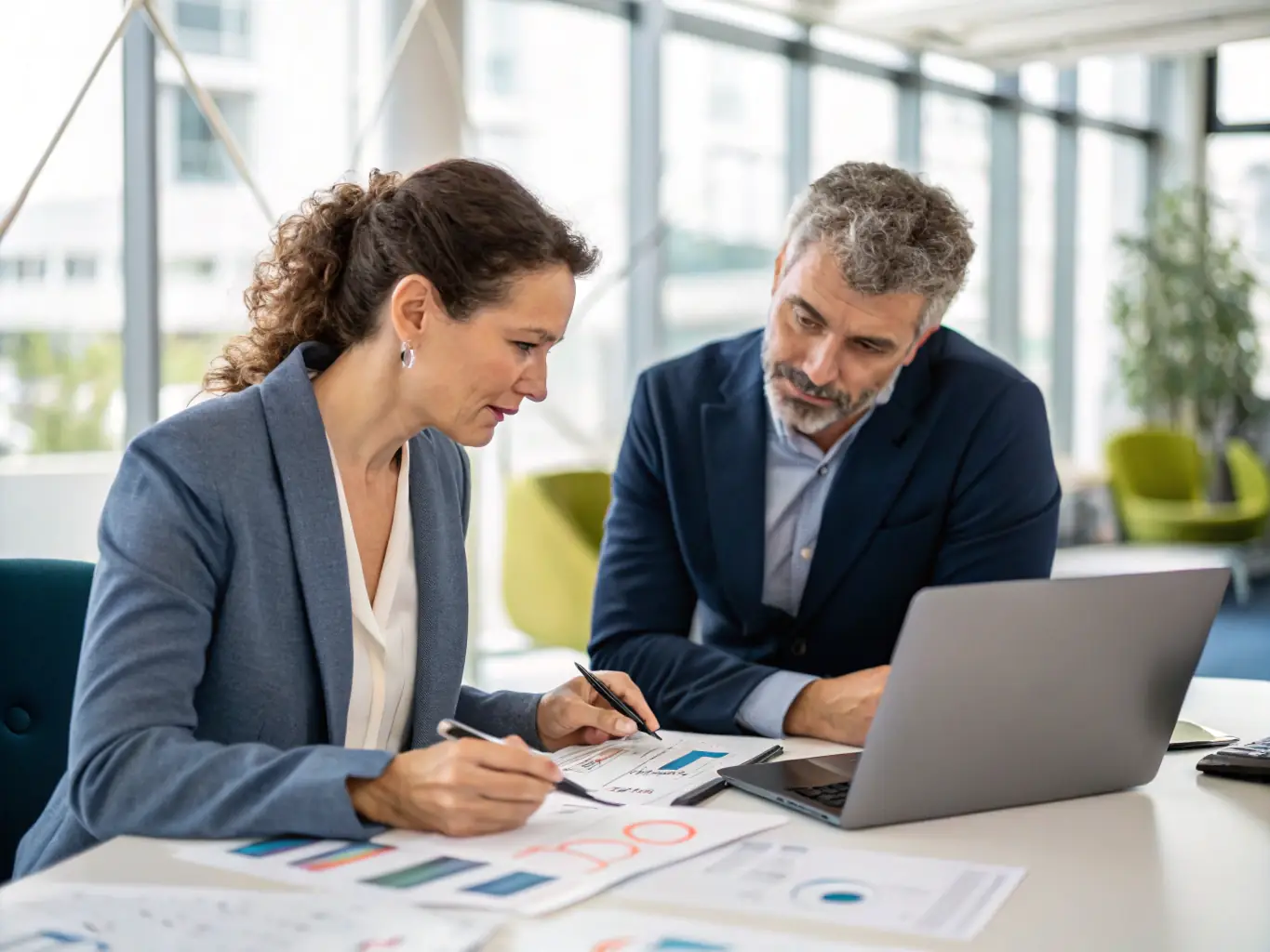 A friendly consultant sitting with a local business owner, reviewing neighborhood demographics and discussing advertising goals, in a bright and modern office setting.